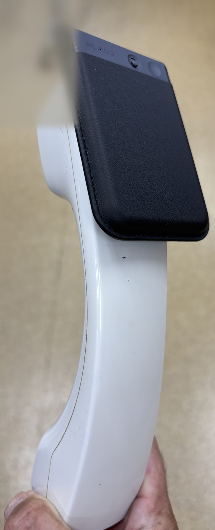 固定電話の受話器にPLAUD Noteをマグネットで固定した実機の様子。受話口の近くにレコーダーを添えられている